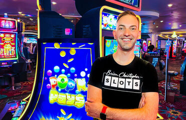 Brian Christopher stands near Gaming Arts' Pop'N Pays machine